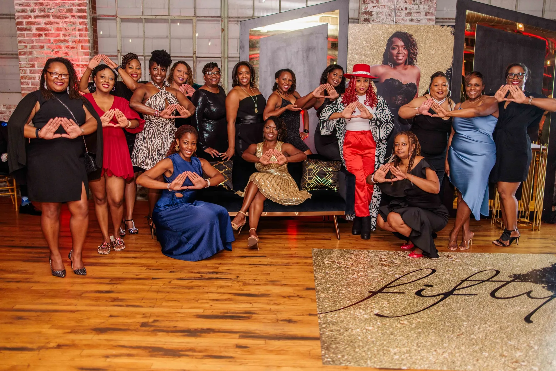 Sorority sisters throwing their hand sign together on the dance floor at a 50th birthday.