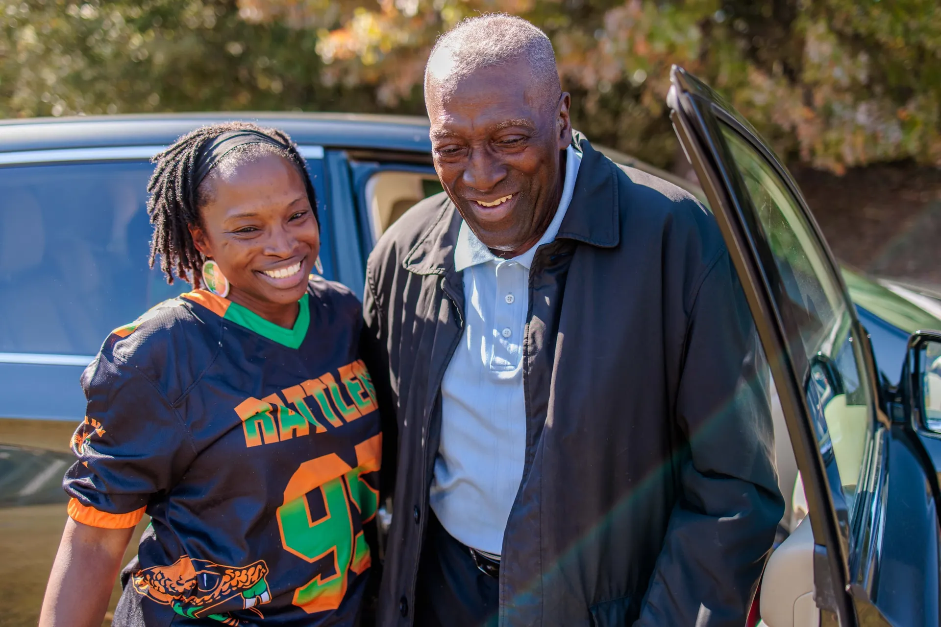 The guest of honor arriving at his 80th birthday, greeted by a guest in a jersey.