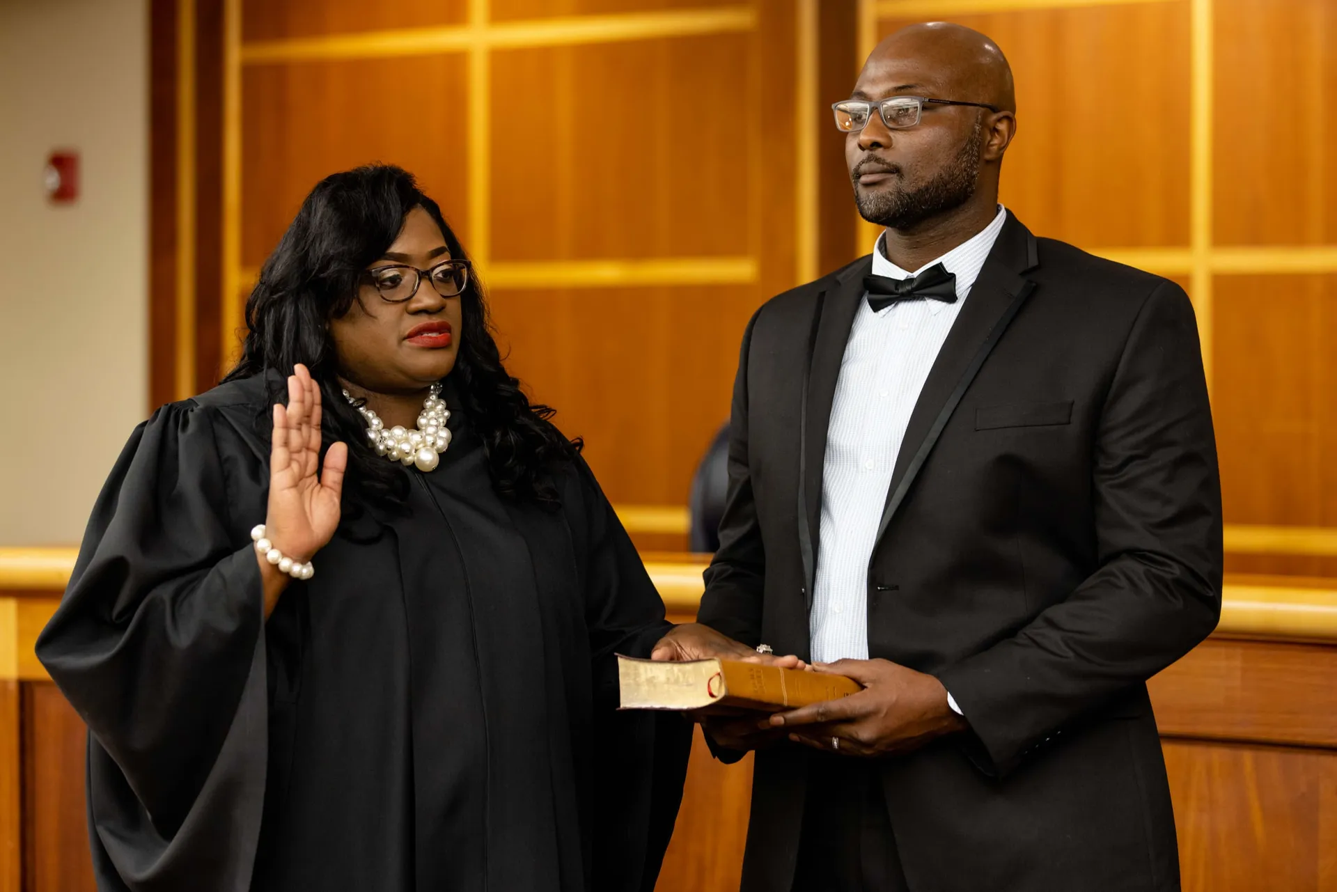 A judge in her robe raising her right hand as she is sworn in.