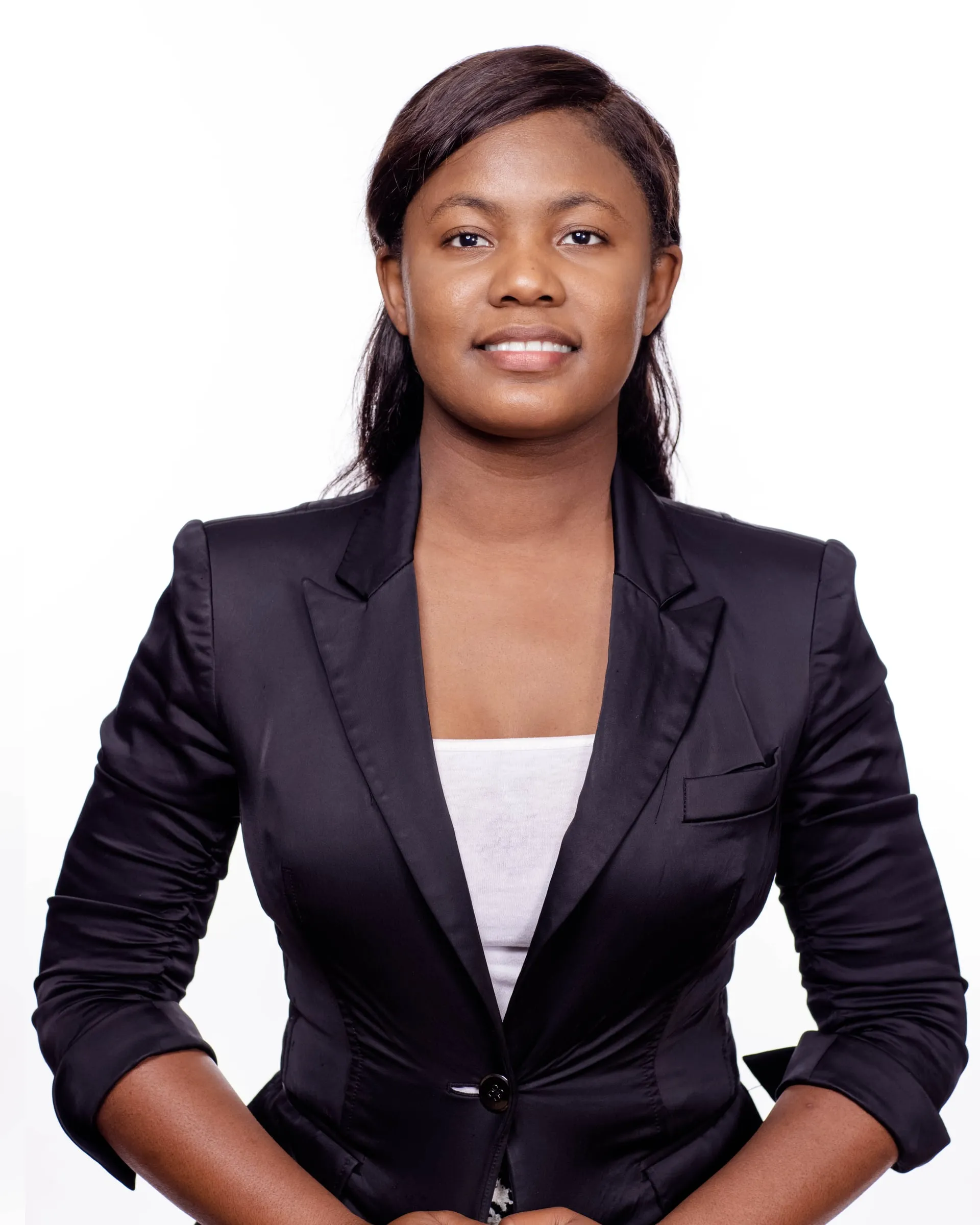 A studio portrait of a woman in a black blazer over a white top, hands clasped.